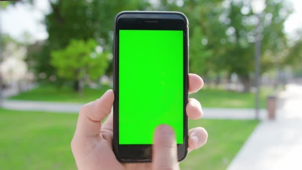 Ręka trzymająca telefon z zielonym ekranem — Wideo stockowe