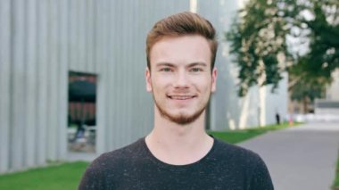 Kasabada gülümseyen sakallı kızıl saçlı adam.