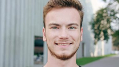 Kasabada gülümseyen sakallı kızıl saçlı adam.