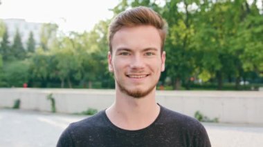 Kasabada gülümseyen sakallı kızıl saçlı adam.