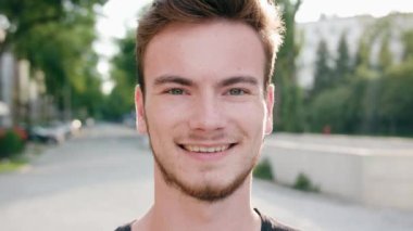 Kasabada gülümseyen sakallı kızıl saçlı adam.