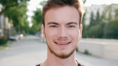 Kasabada gülümseyen sakallı kızıl saçlı adam.