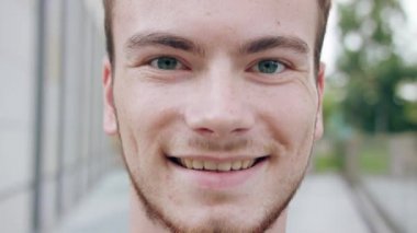 Kasabada gülümseyen sakallı kızıl saçlı adam.