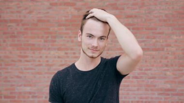 Bir tuğla duvara sakallı mutlu gülümseyen adam