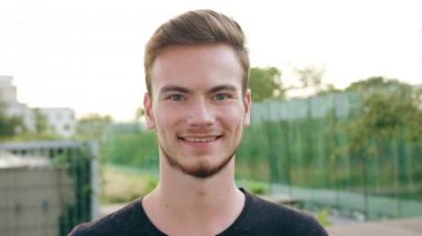 Kasabada gülümseyen sakallı kızıl saçlı adam.