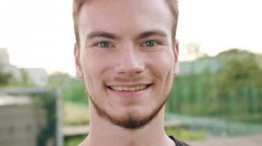 Kasabada gülümseyen sakallı kızıl saçlı adam.