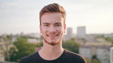 Kasabada gülümseyen sakallı kızıl saçlı adam.