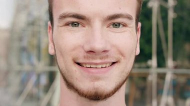 Kasabada gülümseyen sakallı kızıl saçlı adam.