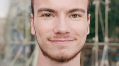 Kasabada gülümseyen sakallı kızıl saçlı adam.