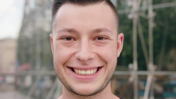 Homme aux cheveux foncés avec la barbe souriant en ville — Video