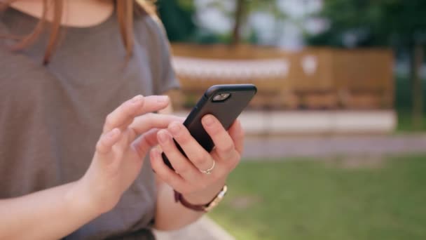 Primer plano de la mano de las mujeres usando un teléfono al aire libre — Vídeos de Stock