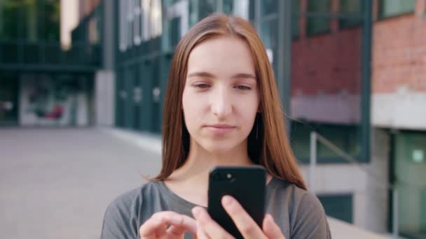 若い女性が町で携帯電話を使用して — ストック動画