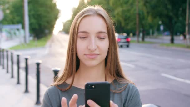 Jovencita usando un teléfono en la ciudad — Vídeos de Stock