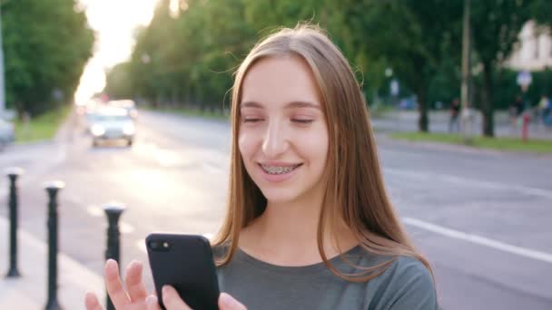 Giovane signora utilizzando un telefono in città — Video Stock