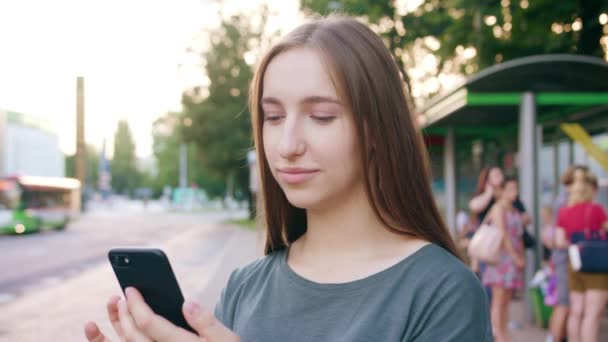 Jovencita usando un teléfono en la ciudad — Vídeos de Stock