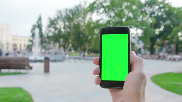 Una mano sosteniendo un teléfono con una pantalla verde — Vídeo de stock