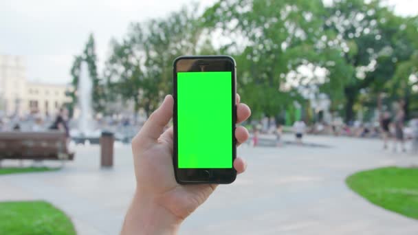 Рука тримає телефон із зеленим екраном — стокове відео