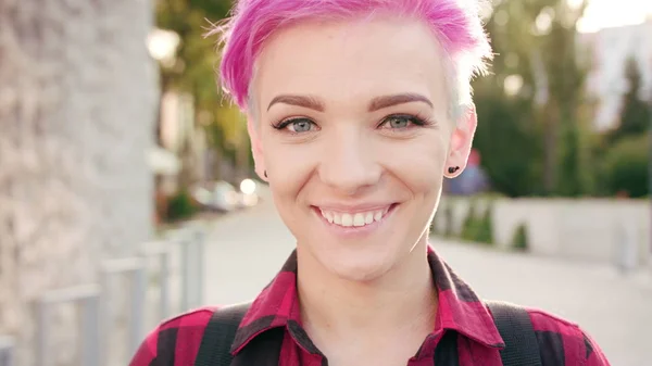 Mujer sonriente feliz con el pelo rosa en la ciudad —  Fotos de Stock