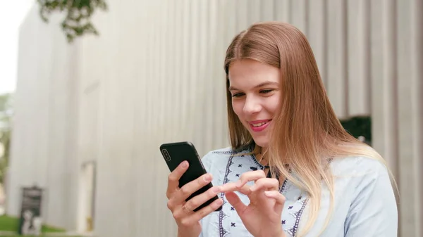 Jovencita usando un teléfono en la ciudad — Foto de Stock