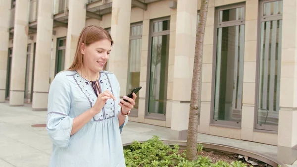 Jovencita usando un teléfono en la ciudad — Foto de Stock