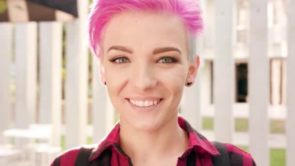 Lyckligt leende kvinna med rosa hår i staden — Stockvideo
