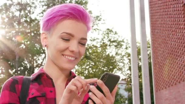 Nő, rózsaszín rövid haj, a telefon használata a városban — Stock videók