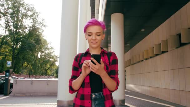 Γυναίκα με ροζ Σύντομη μαλλιά χρησιμοποιώντας ένα τηλέφωνο στην πόλη — Αρχείο Βίντεο