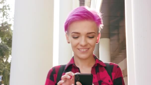 Женщина с короткими розовыми волосами с помощью телефона в городе — стоковое видео