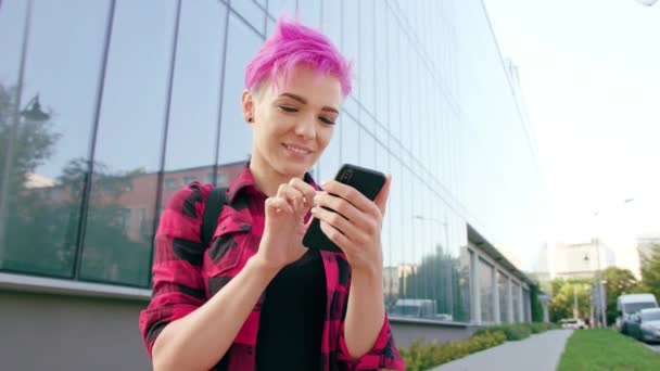 街で携帯電話を使用してピンクの短い髪の女性 — ストック動画