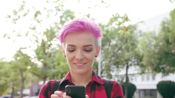 Nő, rózsaszín rövid haj, a telefon használata a városban — Stock videók