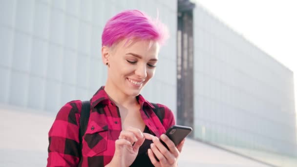 在镇上使用电话的粉红色短发的妇女 — 图库视频影像