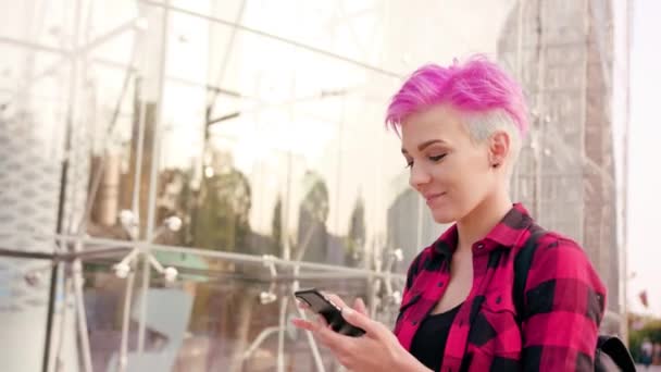 Femme aux cheveux courts roses utilisant un téléphone en ville — Video