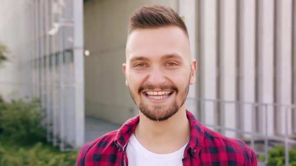 Joven con barba sonriendo en la ciudad — Vídeos de Stock