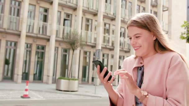 Giovane signora utilizzando un telefono in città — Video Stock