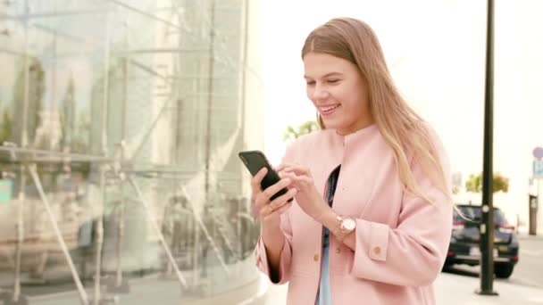 Jovencita usando un teléfono en la ciudad — Vídeo de stock