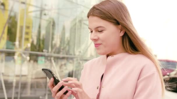 Jovencita usando un teléfono en la ciudad — Vídeo de stock