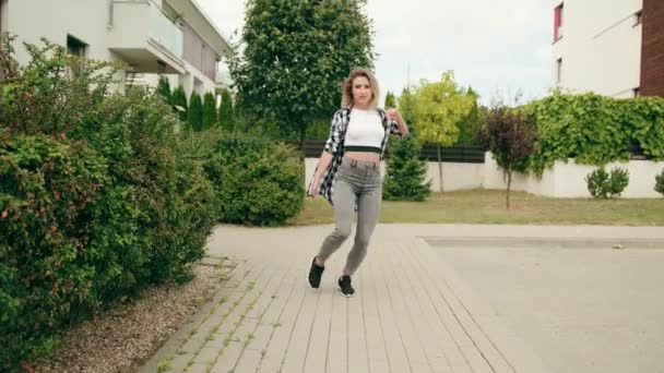 Молодая женщина танцует на улице — стоковое видео