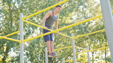 Pull-up gücü eğitim tatbikatı. Bir çok uygun adam fitness eğitmeni veya kişisel bir eğitmen crossfit egzersiz bir parçası olarak çalışma dışarı onun kol kasları açık plaj jimnastiği atlet ince.