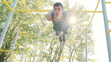 Kaslı adam yatay çubuğu egzersizleri yapıyor