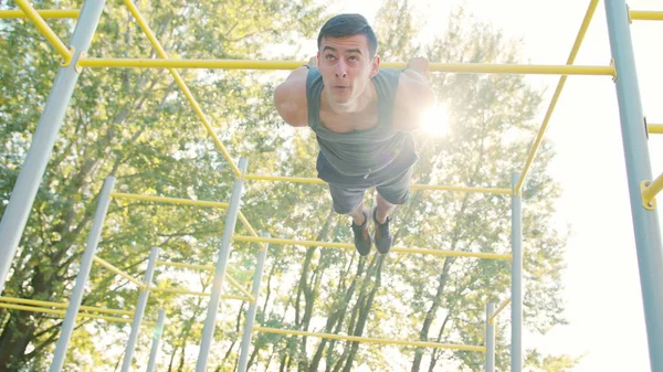 Kaslı adam yatay çubuğu egzersizleri yapıyor