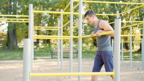 М'язистий чоловік робить вправи на горизонтальній панелі — стокове відео