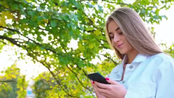 Женщина с помощью смартфона выглядит счастливой — стоковое видео