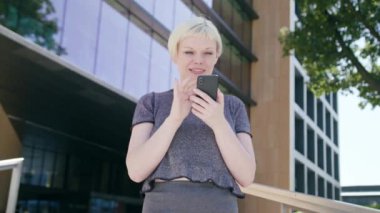 Genç sarışın Bayan kasabada bir telefon kullanma