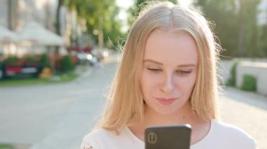 Genç sarışın Bayan kasabada bir telefon kullanma