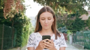 Genç Bayan kullanma şehir yürüyüş sırasında bir telefon