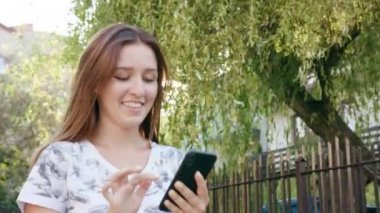 Genç Bayan kullanma şehir yürüyüş sırasında bir telefon