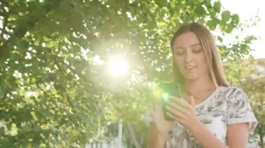 Genç Bayan kullanma şehir yürüyüş sırasında bir telefon