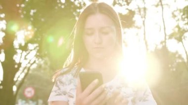 Genç Bayan kullanma şehir yürüyüş sırasında bir telefon