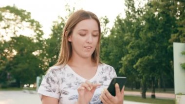 Genç Bayan kullanma şehir yürüyüş sırasında bir telefon