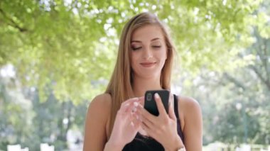 Genç Bayan kullanma şehir yürüyüş sırasında bir telefon